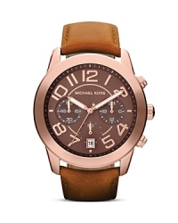 Finished by a classically styled leather strap, this Michael Kors watch flaunts tonal beauty with its rich rose gold plated bezel, chocolate dial, and tony accents.