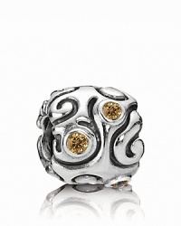 Swirling lines and bezel-set honey zirconia stones make this sterling silver PANDORA charm bewitching.