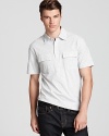 A handsome polo with a thin stripe pattern offers a bit of military appeal with the double pocket detail at the chest.