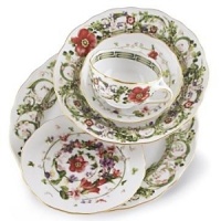 Flower Fantasy bread and butter plates by Versace by Rosenthal. Derived from one of the fashion houses archival prints, this exuberant collection evokes the romance and promise of spring as hand-painted renderings of meadow herbs, sweet-scented flowers and even four-leaf clovers intermingle in a subtle yet lively design.