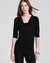 A constellation of beading sparkles from a stunningly draped Eileen Fisher sweater for an effortlessly elegant look. Wear the style with sleek trousers to illuminate the day, then ignite the night.