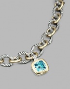 From the Albion Collection. A brilliant blue topaz, richly faceted, surrounded by 18k gold and set in sterling silver. Blue topaz 18k yellow gold and sterling silver About ½ square Hinged clip clasp Made in USA Please note: Necklace sold separately.