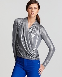 A metallic finish lends fluid dimension to an artfully draped Karen Kane top. Showcase the blouson silhouette against sleek colored denim for a modern look.