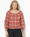 A soft woven cotton top channels western inspiration with a faded plaid pattern and smocked detailing.