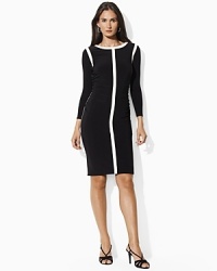 Mod contrast stripes and delicate ruching creating a flattering, curve-conscious silhouette on a sleek matte jersey dress, finished with chic long sleeves for refined elegance.