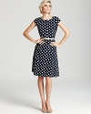 A swing skirt lends a ladylike look to this polka dot printed, figure-flattering Anne Klein dress.