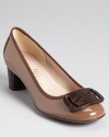 In glossy patent leather, these Ferragamo pumps get topped with a contemporary logo in tonal resin.