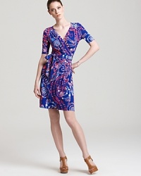 A kaleidoscope of print infuses a classic Lilly Pulitzer wrap dress with modern femininity. Punctuate the vibrant silhouette with acid-bright accents and live colorfully.