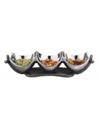 Set or simply decorate the table with the ultra-modern Anvil condiment bowl from Nambe's collection of serveware and serving dishes. A sculptural, iron-finished base cradles contoured silvertone alloy in this innovative Neil Cohen design.