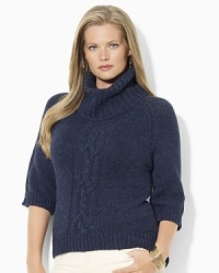 A chunky knit sweater is crafted with an oversized turtleneck and a modern high-low hem.