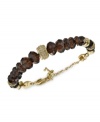 Earthy tones add an elegant touch to this bracelet from Fossil. Crafted from gold-tone stainless steel, the bracelet features beads in shades of smokey topaz for a stylish statement. Adjusts to fit wrist. Approximate length: 7-9 inches.