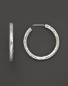 Pure silver hoops with a hammered texture add a quiet elegance to your look.