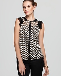 Shimmering polka dots dance across the sheer silhouette of a Tory Burch top, accented with a ruffled neckline and shoulders for a look that proves too much is never enough.