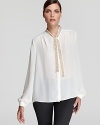 The essential white shirt goes contemporary cool as a shimmering tie neckline and sheer silhouette inspire this VINCE CAMUTO blouse. Team with sleek leather leggings for sophisticated edge.