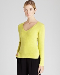 Elevate your every day look with this fluffy angora-blend sweater with a sensually deep v neck, a stylish exposed seam at center back and small side slits at the hem.