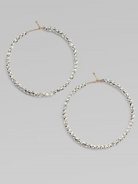 Hoops of 14k gold wire are set with faceted sterling silver beads that catch and reflect light with a warm radiance.14k yellow gold and sterling silverDiameter, about 1½Ear wireMade in USA