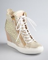 Outrageous style meets athletic fashion in blinged-out Giuseppe Zanotti wedge booties, studded with glittering golden Swarovski crystals. The sneaker heel is back, on wearable wedges.