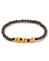 Beaded bronzite sets the stage for 3 skulls carved from antique bone on this statement bracelet from Chan Luu.