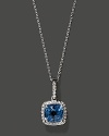 Diamonds frame a faceted blue topaz, set in 14K white gold.