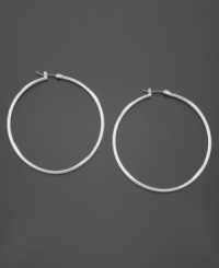 Smooth, shiny hoop earrings add sophistication and glamour to your look. These GUESS earrings are crafted in silvertone mixed metal. Approximate diameter: 2 inches.