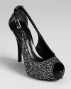 A sparkling, standout slingback from GUESS--dipped in glitter and accented with slick patent details.