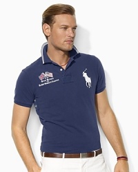 A trim-fitting polo shirt with higher armholes and a shorter hem is crafted from breathable cotton mesh with embroidered flags at the chest for a heritage look.