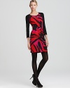 Solid raglan sleeves lend edgy contrast to a vibrantly printed DKNY dress, crafted with a modern front twist.