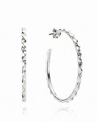 A wavy texture on thin silver hoops adds fresh allure to a classic shape. Earrings by PANDORA.