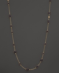 Round and oval grey enamel stations and a diamond highlight this gold chain necklace.