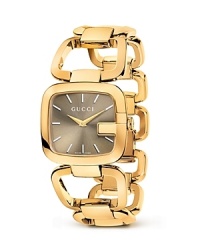 A Gucci bracelet watch with gold-tone links makes a luxe presentation with a sunbrushed dial.