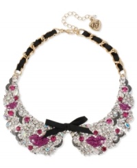 Grab a kiss from Betsey Johnson. This darling collar necklace showcases a gold tone chain intertwined with black grosgrain ribbon, black grosgrain ribbon bows, fuchsia glitter lips and clear crystal accents. Crafted in antiqued gold tone mixed metal. Approximate length: 15 inches + 3-inch extender. Approximate drop: 1-1/2 inches.