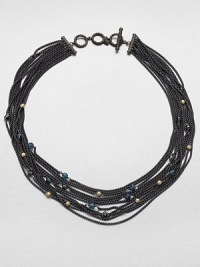 Delicate chains of blackened sterling silver are randomly sprinkled with tiny faceted beads of blue topaz, hematite and 18k gold in this dramatic design.Blue topaz and hematiteSterling silver and 18k yellow goldLength, about 18Cable toggle closureImported