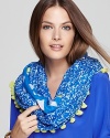 Bright pom poms bring a fun finish to DIANE von FURSTENBERG's vacation-perfect infinity scarf, boasting double-sided prints.