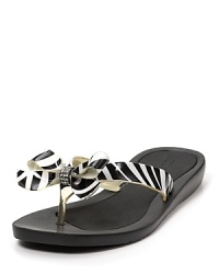 A GUESS revamp of basic flip flops: fierce zebra print combined with sparkling rhinestone-accented bows for bold day-to-day style.