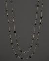 Round and oval grey enamel stations and a diamond highlight this gold chain necklace.