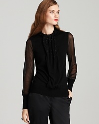 Unleash your dark side as sheer sleeves and sequin-studded ruffles lend dramatic presence to a Tory Burch sweater.