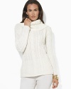 A soft cable-knit sweater is knit from a plush blend of wool, angora and cashmere yarns and finished with elegant buttons at the cowl neckline.