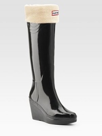 Glossy rubber rainwear now revamped with an embossed Hunter crest and solid rubber wedge.Heel, 3 (75mm) Rubber platform, ½ (15mm) Compares to a 2½ heel (65mm) Shaft, 14 Leg circumference, 15 Round toe Pull-on style Padded insole Rubber sole ImportedOUR FIT MODEL RECOMMENDS ordering true whole size; ½ sizes should order the next whole size up. 