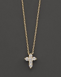 A diamond cross necklace in yellow gold. With signature ruby accent. Designed by Roberto Coin.