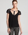 Provocative cutout details enhance both sides of this seductive BCBGMAXAZRIA top--black sequins lend the subtle sparkle for after-dark perfection.