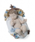 A true bundle of joy, this baby Jesus figurine snuggles up to a powder-blue blanket in a basket that's decorated with blooms and entirely handcrafted in premium Lladro porcelain.