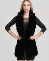 In plush faux fur, Black Halo's Braiden vest lends a cozy layer over a fitted sheath dress.