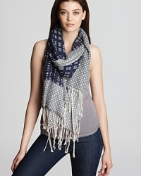 A stylish pairing of plaid and polka dot embellish this luxuriously soft scarf from Tory Burch.