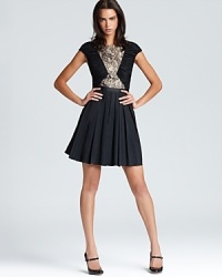 A pleated skirt lends a youthful look to Aqua's lace-detailed dress--complete the look with patent maryjane pumps.