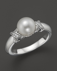 A cultured freshwater pearl is detailed in sparkling diamonds, set on a sterling silver band. From Lagos.