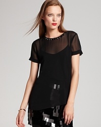 Bring your wardrobe back to black in a sheer DKNY blouse accented with a stunning beaded neckline and fringed sleeves for serious fashion presence.