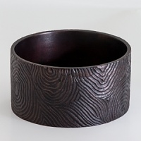 Artfully hand cast and painted in a deep, rich bronze hue, this rustic coaster from Natori replicates the look of natural wood grain.