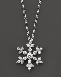 A diamond snowflake pendant has a round center stone. Set in 14 Kt. white gold.