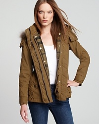 Melding fashion with function, a utilitarian Burberry Brit anorak features a detachable quilted liner and a zip-on hood for style suited for the elements. Plush fur trim snaps onto the hood for a touch of exotic edge.