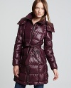 A rich jewel tone and a hint of shine lend glossy luster to a Burberry Brit down coat, cinched at the waist for a chic approach to cold-weather style.